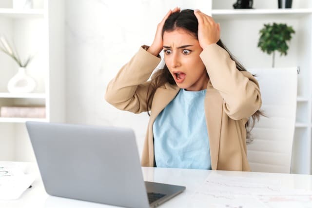 Person vor dem Rechner, die einen Fehler auf ihrer Webseite entdeckt
